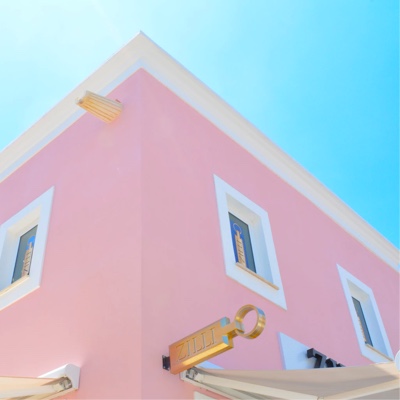 a skyward view of the corner of a beautiful pink low-rise building